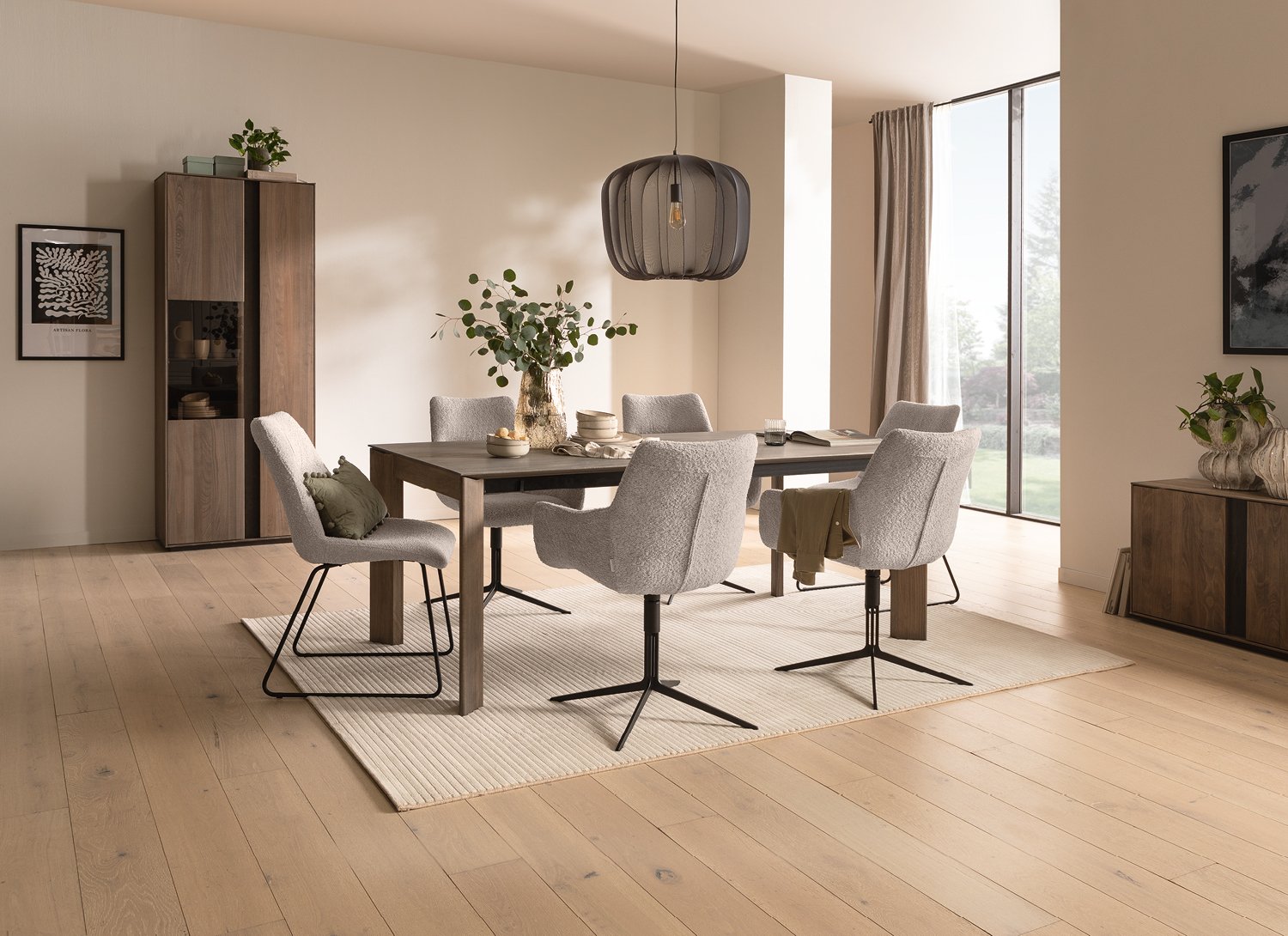 Holztisch mit vier Polsterstühlen auf Teppich, Vitrine links und Sideboard rechts am Fenster
