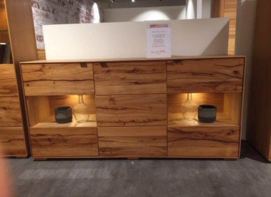 Sideboard aus Holz mit Schubladen und zwei beleuchteten offenen Fächern, weiße Platte oben